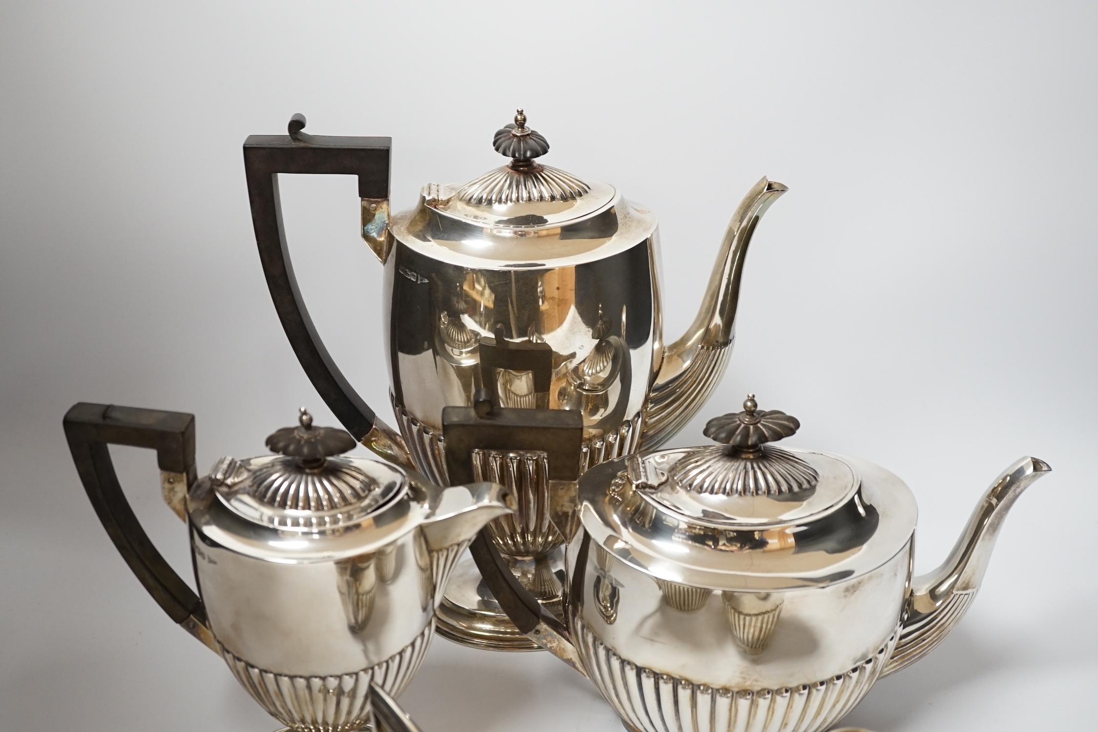 An Edwardian matched demi fluted silver five piece tea and coffee service, by Walker & Hall, Chester, 1906 and Sheffield, 1907/1908, the coffee pot and hot water jug with pedestal foot, gross weight 79.3oz.